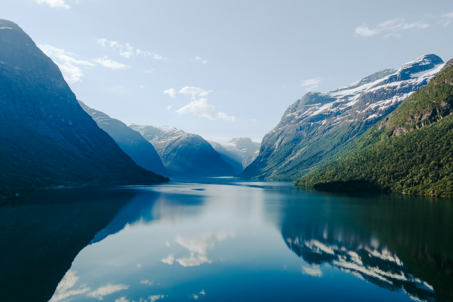 Een rustig blauw fjord tussen groene bergen